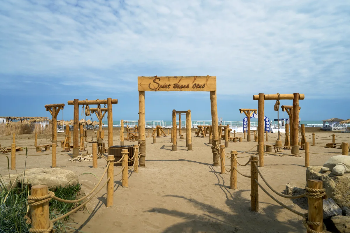 Деревянная арка Sport Beach Club и тренажёры на песке — соседи кортов